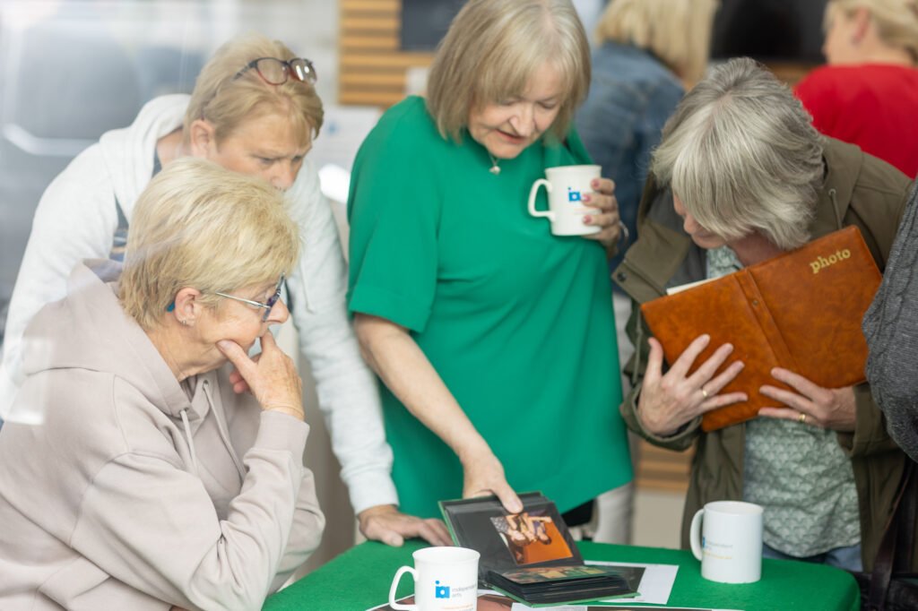 Women looking at photos and swapping stories