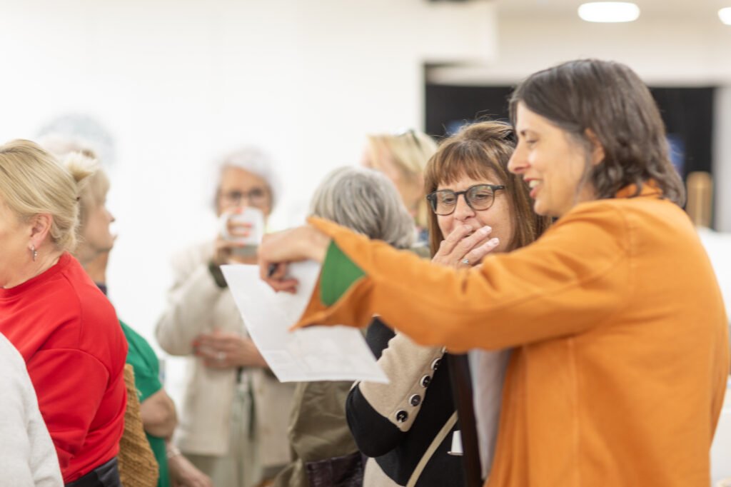 Women looking at photos and swapping stories