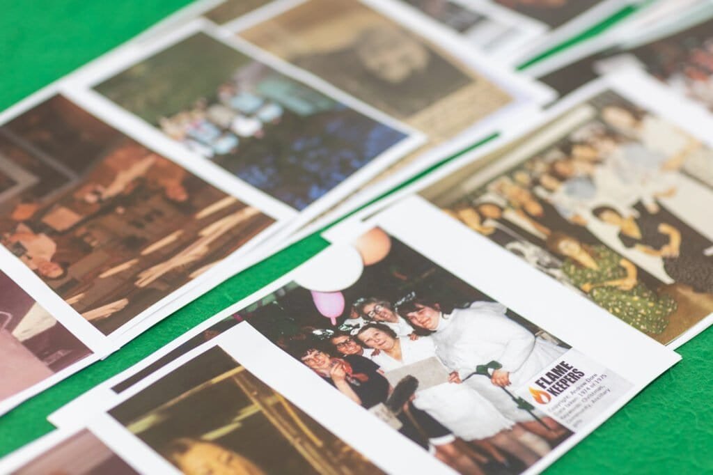 A selection of prints of old Ronson photos spread across a table ready for people to look through